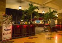 Un restaurante con bar con palmeras y un cartel. en Beach Luxury Hotel, en Karachi