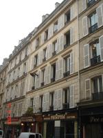 a large building with white shuttered windows on a street at MULTIRESIDENCE L&#39;ELYSEE Paris in Paris