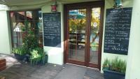 a restaurant with a chalkboard on the side of a building at Chatki Qdłatki in Kluszkowce