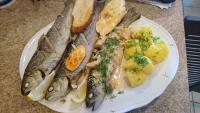 a plate of food with fish and potatoes on a table at Chatki Qdłatki in Kluszkowce