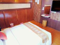 a large bed in a room with wood paneling at Hong Ben Hotel in Kenting