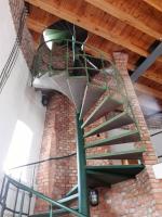 a green spiral staircase in a brick building at Wasserturm Angermünde in Angermünde