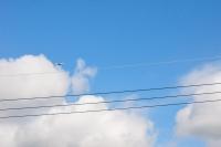 a plane flying in the sky above power lines at Fully One B&amp;B in Taitung City