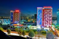 una ciudad iluminada por la noche con edificios altos en Bayangol Hotel, en Ulán Bator
