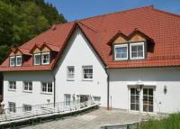 a large white building with a red roof at Zur Sommerfrische Lothramühle in Drognitz