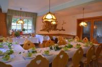 a dining room with tables and chairs with white tablecloths at Zur Sommerfrische Lothramühle in Drognitz