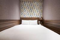 a large white bed in a room with a window at Tomorrow Hotel in Taipei