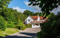 Casa blanca con techo rojo y entrada en Aubrey Park Hotel, en Hemel Hempstead