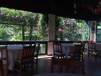 una sala da pranzo con tavoli, sedie e fiori di Tureck Garten Hotel a Corupá