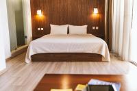 Un dormitorio con una cama grande con una pared de madera. en Du Lac, en Agios Nikolaos