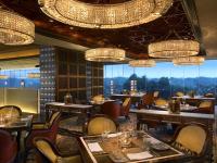 a restaurant with tables and chairs and chandeliers at The Leela Ambience Gurugram Hotel & Residences - The Luxury Urban Sanctuary in Gurgaon