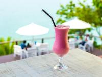 a pink drink in a glass sitting on a table at Barra do Piuva Porto Hotel in Ilhabela