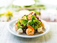 a white plate with a salad on a table at Barra do Piuva Porto Hotel in Ilhabela