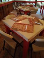 Un grupo de mesas en un restaurante con sillas. en Blessings At Strawberry Fields, en Robins Bay