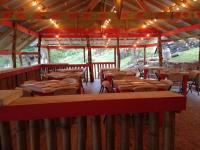 Un restaurante con mesas y sillas de madera y luces. en Blessings At Strawberry Fields, en Robins Bay