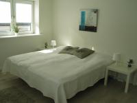 a bedroom with a large white bed with two windows at Aalborg City Rooms ApS in Aalborg