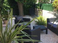 a garden with two chairs and a table and a plant at Les Lones avec jardin in Six-Fours-les-Plages