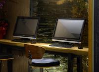 two computer monitors sitting on a desk with a chair at Yunoyado Onsen Hot Spring Hotel -Xinyi Branch in Jiaoxi