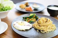 a plate with noodles and eggs and vegetables on a table at Yunoyado Onsen Hot Spring Hotel -Xinyi Branch in Jiaoxi