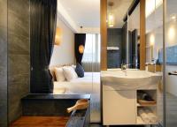 a bathroom with a sink and a bedroom at Yunoyado Onsen Hot Spring Hotel -Xinyi Branch in Jiaoxi