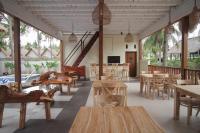 a restaurant with wooden tables and chairs and windows at Sadev Resort in Gili Trawangan