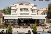 Un restaurante con mesas y sillas frente a un edificio. en Selena Hotel, en Balchik