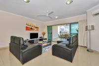 a living room with two leather chairs and a television at Argus Apartments Darwin in Darwin