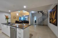 a kitchen and living room with a staircase at Argus Apartments Darwin in Darwin