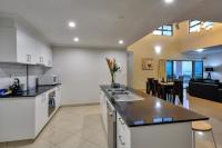 an open kitchen and living room with a view of the ocean at Argus Apartments Darwin in Darwin