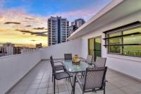 a balcony with a table and chairs on a building at Argus Apartments Darwin in Darwin