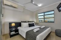 a bedroom with a large bed and a window at Argus Apartments Darwin in Darwin