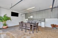 a dining room with a table and chairs and a tv at Argus Apartments Darwin in Darwin