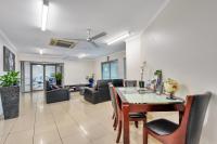 a dining room and living room with a table and chairs at Argus Apartments Darwin in Darwin