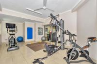 a gym with two treadmills and two exercise bikes at Argus Apartments Darwin in Darwin