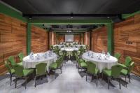 a conference room with tables and green chairs at IOTA Hotel Tbilisi in Tbilisi City