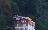 un edificio con luces en el lateral de una montaña en Summit Hermon Hotel &amp; Spa, en Darjeeling