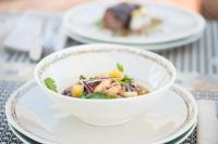 a bowl of soup on a plate on a table at Hotel Boutique Varadero in Zahara de los Atunes