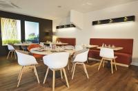 ein Esszimmer mit weißen Stühlen und Tischen in einem Restaurant in der Unterkunft Kyriad Paris Ouest - Bezons La Défense in Bezons