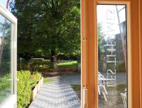 an open door to a patio with a table and chairs at Hotels &amp; Résidences - Les Thermes in Luxeuil-les-Bains