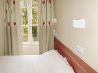 a bedroom with a bed and a window at Hotels &amp; Résidences - Les Thermes in Luxeuil-les-Bains
