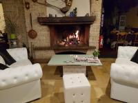 Una sala de estar con chimenea y una mesa y sillas. en Logis Hôtel Saint-Hubert, en Cour-Cheverny