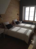 two beds in a room with two windows at Chambres d&#39;hôtes Saint Jean in Nogent-le-Rotrou
