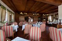 a man standing in a restaurant with tables and chairs at Pension Roez in Göhren-Lebbin