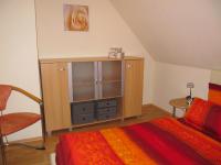 a bedroom with a bed and a cabinet and a table at Pension Roez in Göhren-Lebbin