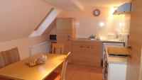 a kitchen with a wooden table and a dining room at Pension Roez in Göhren-Lebbin