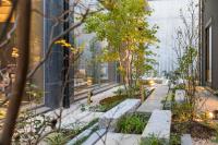a garden with benches and trees in front of a building at Tokyu Stay Kyoto Sanjo-Karasuma in Kyoto