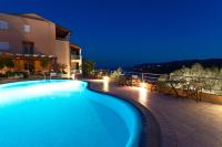 a swimming pool in front of a building at night at Hotel Villa Annette in Rabac