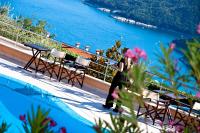 a woman taking a picture of the ocean from a hotel balcony at Hotel Villa Annette in Rabac