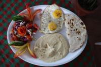 ein Teller mit Frühstücksessen mit Eiern und Salat in der Unterkunft O3 Beach Resort in Palolem