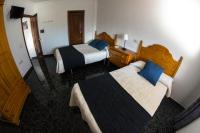 a hotel room with two beds with blue pillows at Hostal Caminito del Rey in Alora